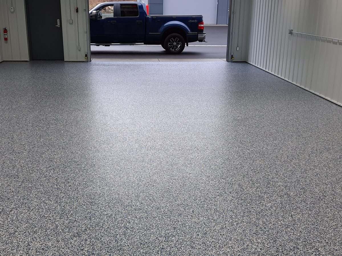 Charcoal flake with polyaspartic topcoat in a commercial bay — ready for daily truck traffic.