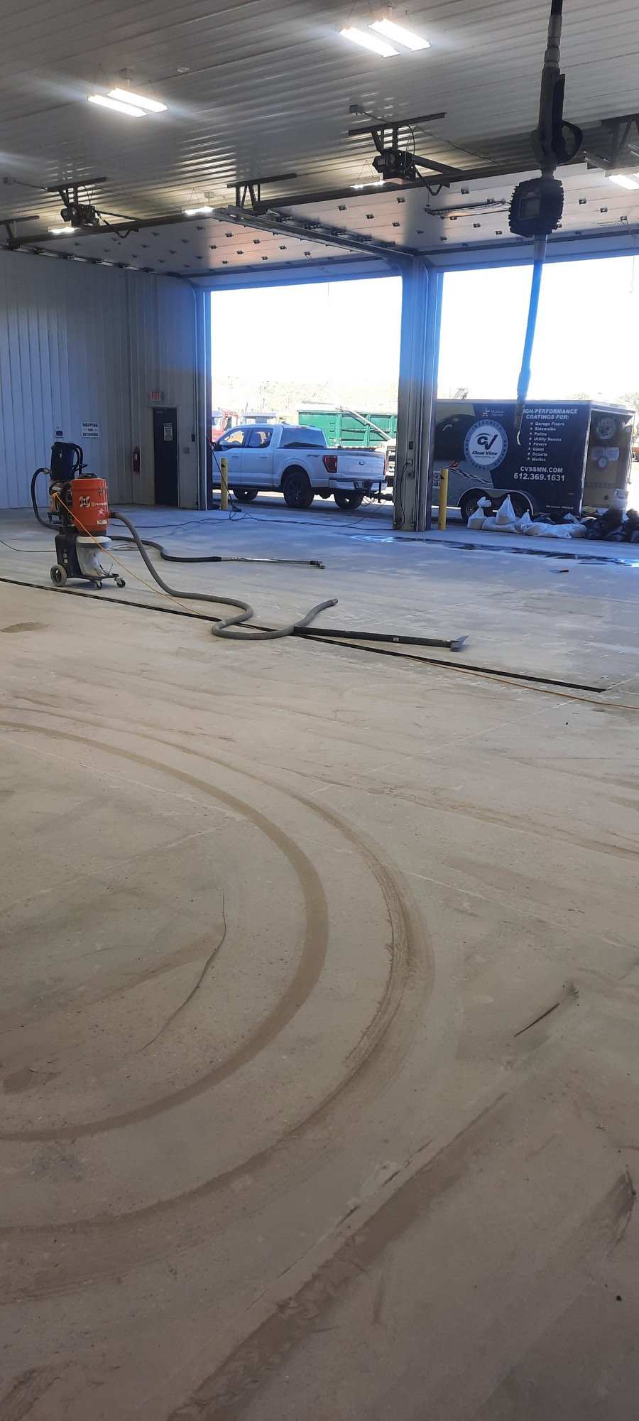 Commercial bay mid-install — diamond grinding the slab open before the polyurea goes down. Prep is why our floors still look like this five years later.